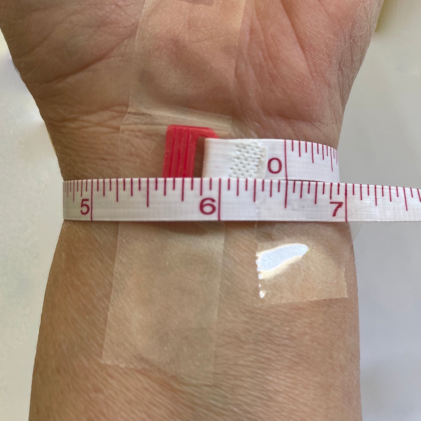 Designer Kimberly Arpaia sizes her wrist using a soft measuring tape. It reads 6.5 inches.